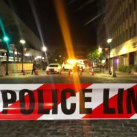 A police car is seen behind police tape blocking a street leading to the Jacksonville Landing area after a shooting in the Florida city Sunday. Florida esports shooting survivor tells story, files lawsuit