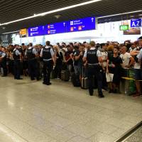 People wait in a terminal during the evacuation of Frankfurt airport in Germany Tuesday. Security lapse sparks evacuation at Frankfurt airport
