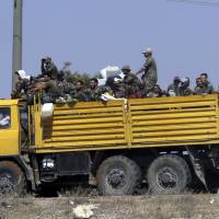 Syrian army soldiers are loaded aboard a truck near the village of Sh.Miskin, Syria, Tuesday. The Russian military said Tuesday that its forces in Syria will help U.N. peacekeepers fully restore patrols along the frontier with the Israeli-occupied Golan Heights, reflecting Moscow’s deepening role in mediating between the decades-old foes. Russia to help restore U.N. patrols near Syria-Israel frontier, displaying Moscow's rising clout