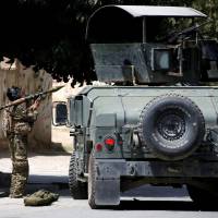 A member of the Afghan security forces prepares to fire an RPG during a battle with insurgents in Kabul Thursday. Islamic State takes credit as gunmen attack intelligence center in Kabul