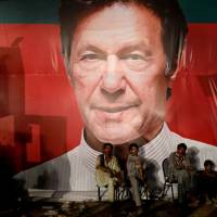 Laborers who set up the venue for a campaign rally by Imran Khan listen to him speak in Karachi on July 22. How a powerful app helped Imran Khan win Pakistan's general election