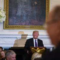 U.S. President Donald Trump smiles during a speech at a dinner celebrating Evangelical leadership in the State Dining Room of the White House in Washingtonon Monday. After the American Legion wrote a letter imploring recognition of late Sen. John McCain, Trump relented during his dinner speech, stating “We very much appreciate everything that Sen. McCain has done for our country.” Trump warns of unrest around midterms after predicting violent change if Democrats take Congress