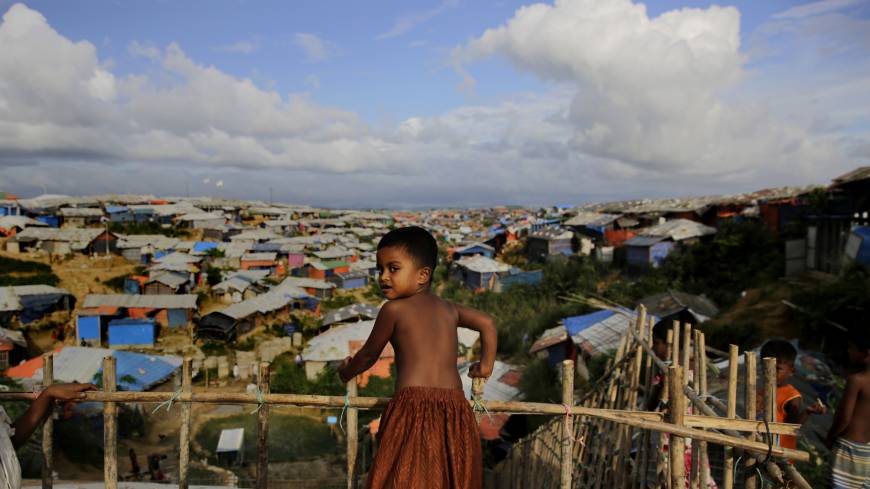 A Rohingya child stands on a bamboo fence overlooking an expanse of makeshift bamboo and tarp shelters at the Kutupalong refugee camp, where they have been living amid uncertainty over their future after they fled Myanmar to escape violence a year ago, in Bangladesh, Sunday. Myanmar court postpones verdict for Reuters journalists