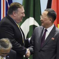 U.S. Secretary of State Mike Pompeo greets North Korea’s Foreign Minister Ri Yong Ho as they prepare for a group photo at the 25th ASEAN Regional Forum Retreat in Singapore on Saturday. North Korea trying to get war-ending statement without ending nuclear program: experts