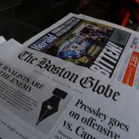 A customer walks past the front page of the Boston Globe newspaper referencing their editorial defense of press freedom and a rebuke of President Donald Trump for denouncing some media organizations as enemies of the American people, part of a nationwide editorial effort coordinated by the Boston Globe, at a newsstand in Cambridge, Massachusetts, Thursday. Over 300 U.S. newspapers hit back at Trump, defend free press