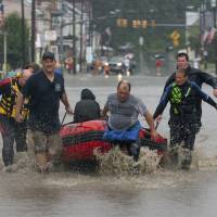 The Ryan Township dive team uses a boat to transport a person for medical problems along Pike Street in Port Carbon, Pennsylvania, on Monday. Overnight rains triggered flash flooding in parts of central and eastern Pennsylvania on Monday, closing down a heavily traveled interstate and sending water into homes in the mountainous coal regions. Drenching downpours snarl transport, prompt rescues in Pennsylvania