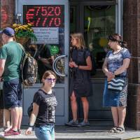 People gather outside a currency exchange office in Moscow on Thursday, when the ruble tumbled to its lowest level against the dollar in almost two years after the United States said it was imposing fresh sanctions on Moscow over the attack with a nerve agent on a former spy in Britain. Russia and China block U.S. additions to U.N. sanctions