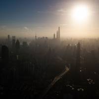 The sun rises over the financial district of Pudong in Shanghai on Monday. To catch up with the U.S., China will have to avoid the middle-income trap that keeps many emerging economies stuck with a per capita GDP of around $15,000. Anything but America: Conflicted China struggles to break the superpower mold