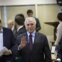 Brazilian President Michel Temer greets the media as he arrives to a meeting for an update on the federal security intervention in Rio de Janeiro Thursday. Closing Brazil border to flood of fleeing Venezuelans 'unthinkable,' Michel Temer says