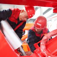 Two workers check cranes that will be exported to the U.S. and Myanmar at a factory in Hengyang, in China’s central Hunan province, on Monday. As trade tensions rise, fewer Americans see China favorably, survey shows