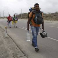 Omar Mujica, a car mechanic from Venezuela, walks to Lima on Sunday along the shoulder of the Pan-American Highway as other Venezuelan migrants follow. Venezuelan migration crisis: How it affects other South American countries