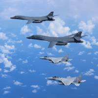 Two Air Self-Defense Force F-15 fighter jets fly alongside two U.S. Air Force B-1B bombers over the vicinity of the East China Sea in September last year. Australian air force and ASDF to hold first joint drills in Japan