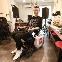 Masatane Muto, representative director of WITH ALS, uses an electric-powered wheelchair in his Tokyo office Aug. 8. From the DJ booth, man with ALS taps into tech to brighten future for all