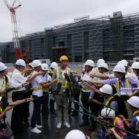 Architect Kengo Kuma speaks to reporters Wednesday in front of a new station being built on Tokyo’s Yamanote line between its existing Shinagawa and Tamachi stations. Partially completed Yamanote Line station, designed by Kengo Kuma, unveiled to media
