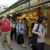 Kurdish asylum-seeker Ali Ayyildiz (center) walks with tour participants along Sensoji Temple’s main avenue in the Asakusa district of Tokyo on July 14. A day in the life of Kurdish asylum-seekers in Tokyo