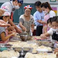 Chinese and Japanese parents make dumplings with their children at a party at Minami Yoshida Elementary School in Yokohama on July 13. Diverse Yokohama school aims to be model for bridging cultural gaps