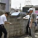 Members of the Takatsuki Board of Education and others inspect a concrete wall along a school commuting route in Osaka Prefecture in July.