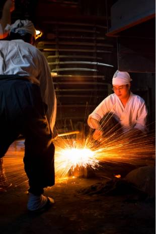Men work on a knife in a workshop in the city of Sakai.