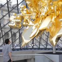 Kohei Nawa looks at his “Throne” (2018) sculpture, which was installed under I.M. Pei’s 1989 glass pyramid at the Louvre in Paris. The Louvre has a new seat of power
