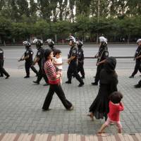 Paramilitary police patrol a Uighur neighborhood in Urumqi, Xinjiang province, China, in July 2009. Are the Uighurs one of China's 56 nations?