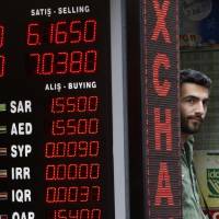 A shop owner stands next to a currency exchange shop in Istanbul on Friday as Turkey’s lira fell once again amid exchanged threats with the United States. Will what happens in Turkey stay in Turkey?