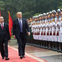 Vietnamese State President Tran Dai Quang and U.S. President Donald Trump review an honor guard in Hanoi on Nov. 12. U.S. makes up lost diplomatic ground over South China Sea