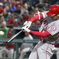 The Angels’ Shohei Ohtani connects on a three-run homer against the Rangers on Saturday in Arlington, Texas. The Angels won 11-7. Ohtani comes off bench to hit three-run homer in victory