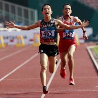 Hiroto Inoue crosses the finish line ahead of Bahrain’s Elhassan Elabbassi to win the men’s marathon at the Asian Games on Saturday. Hiroto Inoue wins Asian Games marathon gold in controversial finish