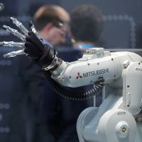 A Mitsubishi Melfa robotic arm, manufactured by Mitsubishi Electric Corp., is displayed at the Robert Bosch GmbH Internet of Things conference in Berlin in February. Despite government push of AI and robots, Japanese fear tech to lead to inequality and job losses: survey