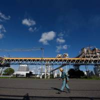 A worker walks past pipelines in Nagoya. Capital spending by Japanese firms rose at the fastest pace in more than a decade in the April-June quarter, according to government data released Monday. Japan saw capital spending rise at fastest pace in over a decade in April-June quarter