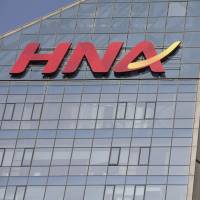 Signage for HNA Group Co. is displayed atop company premises in Beijing. China's HNA Group slims down after asset sales but debt concerns remain