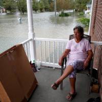 After just rebuilding her home from the floods of 2016, Willie Allen watches the water rise from her porch during Tropical Storm Florence in Lumberton, North Carolina, Sunday. Florence expected to expose gaps in flood insurance, especially in Carolinas