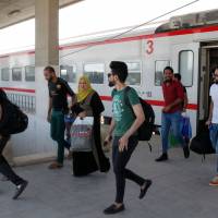 Iraqi passengers disembark from a train coming from Baghdad as it arrives in the city of Fallujah in Anbar province, about 70 km west of the capital, on Aug. 19. The train connecting Baghdad to Falluja crosses the landscapes of western Iraq through car cemeteries, charred tanks and collapsed buildings. Reopened Baghdad-Fallujah railway a tentative sign of progress in Iraq