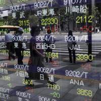 An electronic stock board outside a securities firm in Tokyo Investors hunting bargains in Japan might want to wait till U.S. midterms pass