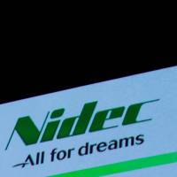 Nidec Corp.’s logo is seen at an earnings results news conference in Tokyo on July 25. Under visionary Shigenobu Nagamori, precision motor-maker Nidec sees EVs driving future profits