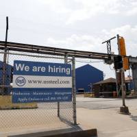 A help wanted sign hangs outside the U.S. Steel Granite City Works facility in Granite City, Illinois, in June. On Tuesday, the Labor Department reports on job openings and labor turnover for July. As U.S. job openings reach unprecedented levels, so do resignations
