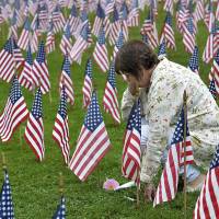 Cheryl Alpert of Weston, Massachusetts, pauses to think about her “best friend,” 9/11 terrorist attack victim Myra Aronson of Boston, after adding a flower and photograph of Aronson to the flag display in memory of victims of the terrorist attacks of Sept. 11, 2001, at Weston Town Green in Weston, Massachusetts, Tuesday morning. Aronson, 50, a public relations professional, was on her way to a conference in California aboard American Airlines Flight 11 when she and 91 others died after the plane crashed into the North Tower at the World Trade Center. Alpert had plans to join her friend of 25 years on the trip but canceled several days prior. U.S. marks 9/11 with somber tributes and prayers for unity without politics as Trump speaks at crash site