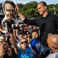 The son of Brazilian right-wing presidential candidate Jair Bolsonaro, Eduardo Bolsonaro, gives his thumb up to his father’s supporters gathering in front of the Israelita Albert Einstein Hospital in Sao PauloSunday after it was announced that their stabbed leader left the intensive care unit. Stabbed Brazil election front-runner leaves intensive care: hospital