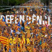 People wave pro-independence Catalan flags ‘Esteladas’ while holding letters reading “independence” during a pro-independence demonstration in Barcelona, Spain, Tuesday to mark the National Day of Catalonia, the “Diada.” Catalan separatists will seek to put on a show of strength and unity at celebrations of the region’s national day, nearly a year after a failed attempt to break away from Spain. 1 million protesters rally in Barcelona and again call for Catalan independence