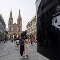 Tourists take pictures in front of the Sacred Heart Cathedral in Guangzhou, China, on Saturday. China comes out ahead in Vatican deal, analysts say
