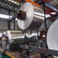 Rolls of sheet aluminum are seen Thursday at a factory in Zouping, in China’s Shandong province. China's industrial output tops forecasts but investment growth sinks to new low