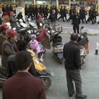 Residents watch a convoy of security personnel in a show of force through central Kashgar in western China’s Xinjiang region last fall. Two U.S. lawmakers are urging the extension of American export restrictions to prevent sales of equipment that could be used in China’s massive security clampdown targeting the Xinjiang region’s native Muslim population. Sen. Marco Rubio and Rep. Chris Smith said in a letter Wednesday to the U.S. commerce secretary that they want foreign entities, including businesses, research institutions, government and private organizations, and individuals seen as profiting from the clampdown added to a watch list. China is 'educating' Muslims to avoid extremism's spread, not mistreating them: Beijing official