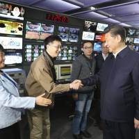 Chinese President Xi Jinping shakes hands with staff members at the control room of China Central Television (CCTV) in Beijing in this Feb. 19, 2016, file photo released by China’s Xinhua News Agency. China reaches out to U.S. over demand that state-run outlets register as foreign agents