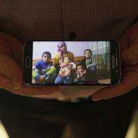 Adil, a businessman from Kashgar, China, with five children, shows an image of his family left behind in China while being interviewed in Istanbul. He got stuck in Turkey during a business trip after hearing that the Chinese government was seizing passports, and hasn’t seen his children since. China, seeking to subdue Muslim Uighurs in Xinjiang, separates children from families