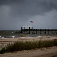 Storm clouds loom over a pier as Tropical Storm Gordon approaches in Waveland, Mississippi,Tuesday, Gordon aims to hit U.S. Gulf Coast as hurricane after nightfall