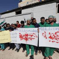 Syrian health sector workers hold banners during a rally in the village of Atmeh in the northern Idlib province, demanding that hospitals be protected in the case of an upcoming offensive, on Sunday. The Syrian regime and its Russian ally are threatening an offensive to retake the northwestern province of Idlib, Syria’s last rebel bastion. Turkey in the middle as Syrian rebels in Idlib prepare for last stand