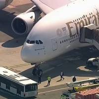 In this frame from video, a person walks off an Emirates plane at JFK International Airport to a waiting bus on Wednesday in New York as emergency response crews gather outside the plane amid reports of ill passengers aboard the flight from Dubai. 11 hospitalized with flu-like symptoms in New York following Emirates flight