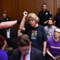 A protester shouts during a hearing of the Senate Judiciary Committee on the nomination of Brett Kavanaugh to the U.S. Supreme Court Tuesday in Washington. President Donald Trump’s newest Supreme Court nominee, Kavanaugh, is expected to face punishing questioning from Democrats this week over his endorsement of presidential immunity and his opposition to abortion. Some two dozen witnesses are lined up to argue for and against confirming Kavanaugh, who could swing the nine-member high court decidedly in conservatives’ favor for years to come. Chaos marks start of Brett Kavanaugh confirmation hearing in U.S. Senate