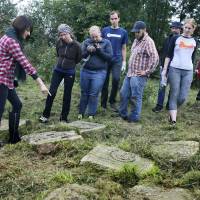 U.S. citizen Marla Raucher Osborn (left), a Rohatyn Jewish heritage project leader, shows volunteers the gravestones Wednesday at an old Jewish cemetery in Rohatyn close to Lviv, Ukraine, a few days before the 75th anniversary of the annihilation of the city’s Jewish population by Nazi Germany. The commemoration comes amid a larger attempt in Ukraine to remember and celebrate the lost Jewish world in a part of Ukraine that before World War II was part of Poland and was the third-largest Polish Jewish community. Ukrainian city of Lviv remembers annihilation of Jews on Holocaust anniversary