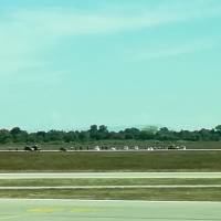 This picture taken with a mobile phone through the window of a plane shows French gendarmes and police arresting a man on the tarmac of Lyon’s Saint-Exupery airport after he managed to get on the runways with his car Monday in Colombier-Saugnieu. Driver plows through Lyon airport terminal before runway chase, capture